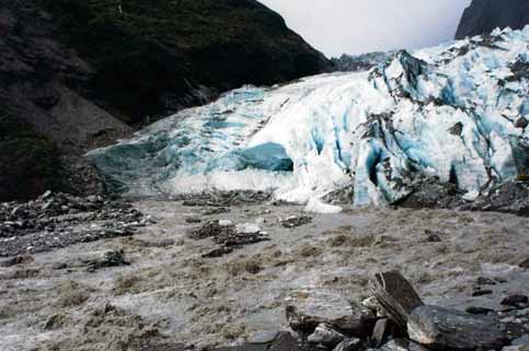 Meltwater can carry lots of sediment away from the glacier.  Can you see the mouth of the tunnel at the bottom of the glacier?  Franz Josef Glacier, Westland Tai Poutini National Park, South Island, New Zealand. © Abigail Burt