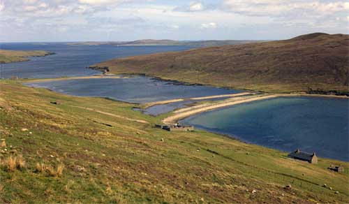 Long thin barrier beaches connect the two hills.  There is a lagoon between the barriers. Shetland, UK.