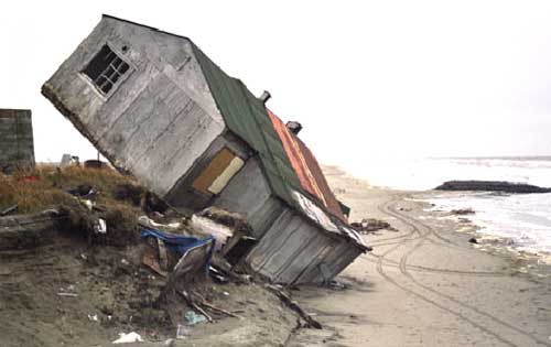 Una casa pericolosamente inclinata a causa dell'erosione costiera.